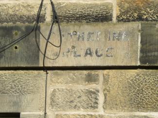 Faded black letters painted directly onto the masonry, reading CATHERINE PLACE.