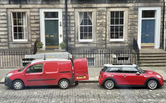 Two identically coloured cars parked facing in opposite directions.